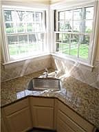 Close up of new granite & backsplash and sunny corner windows.