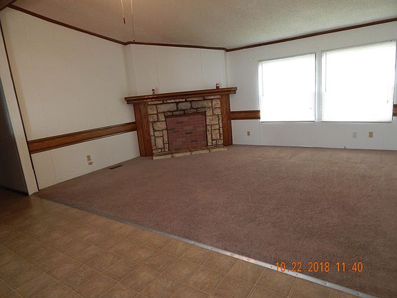 Looking into living room from dining room. Notice fireplace at rear of photo.
