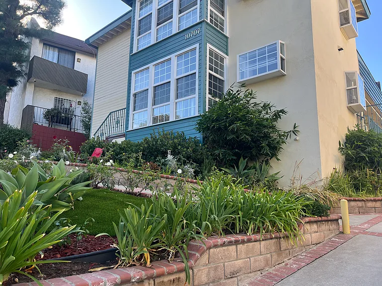 EXTERIOR OF BUILDING SHOWS 2 LARGE GARDEN WINDOWS