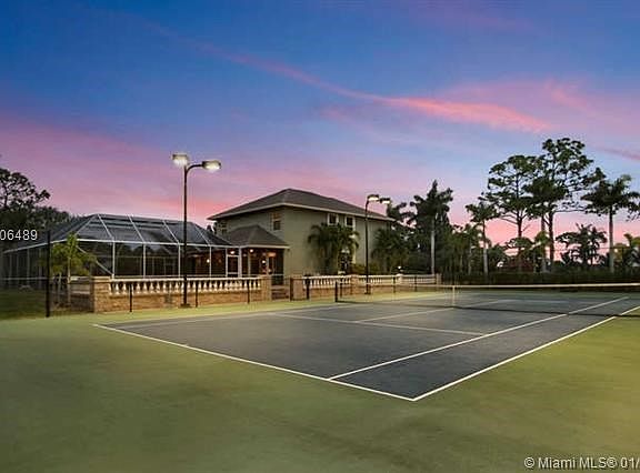 Evening shot of tennis court from back looking towards house
