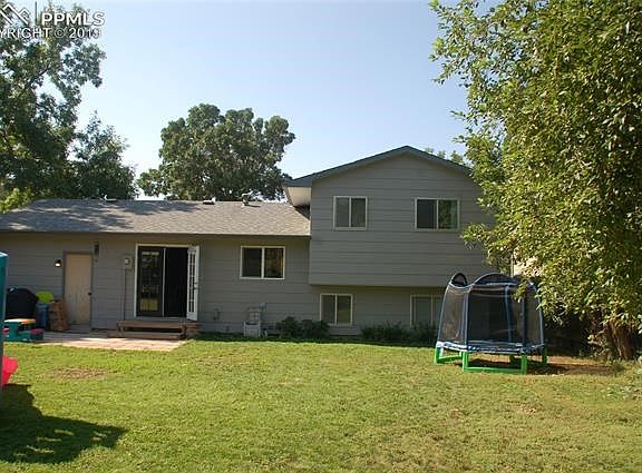 Rear view of home from large backyard