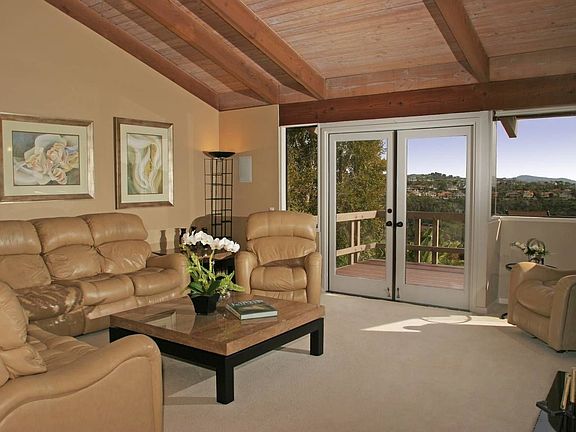 Living room with vaulted ceilings & French doors to deck