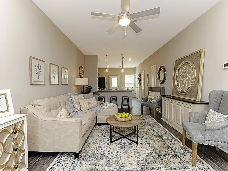 Spacious living room with hardwood-style flooring & ceiling fan