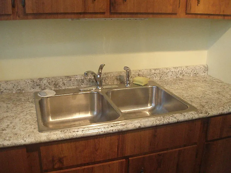 stainless steel kitchen sink with new countertop.