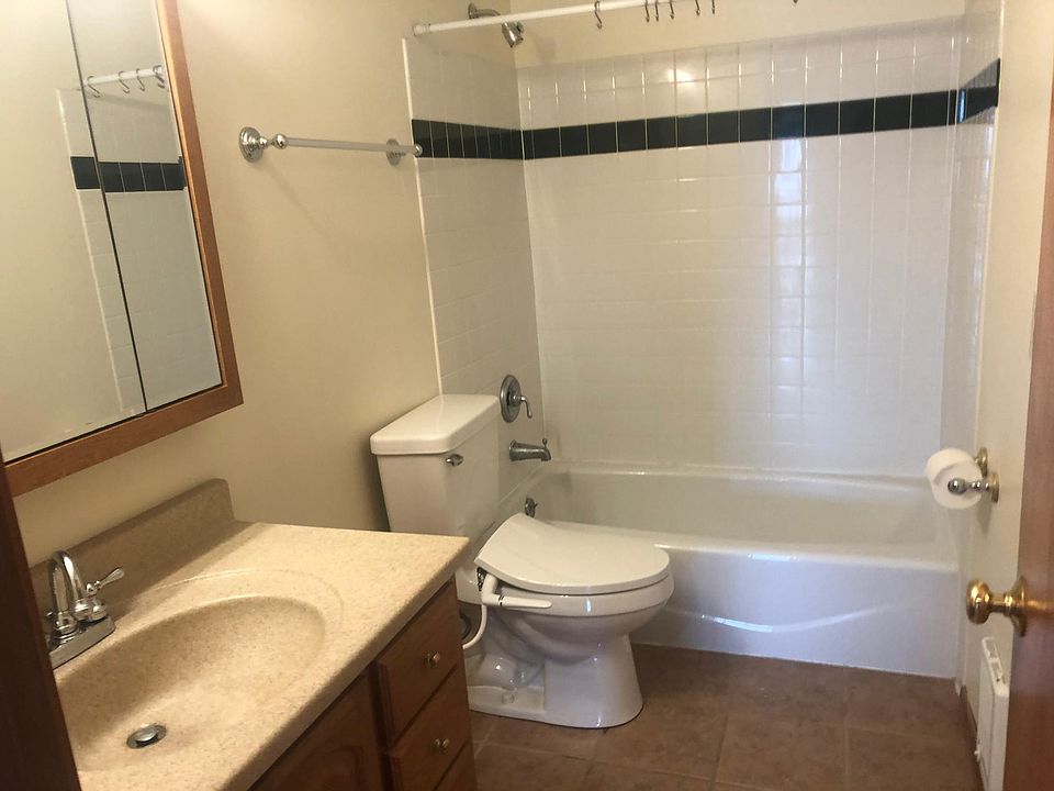 Bathroom with tiled tub area and floor