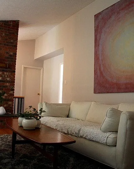 living room, brick fireplace, view to kitchen and entryway.
