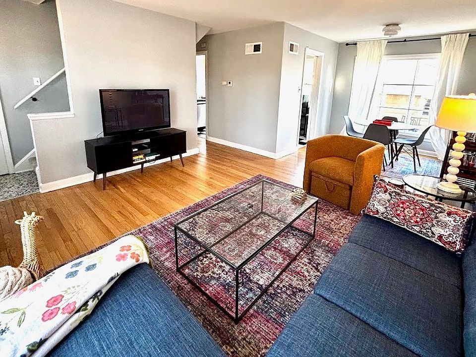 Large open-concept living area with refinished hardwood floors throughout and plenty of natural light