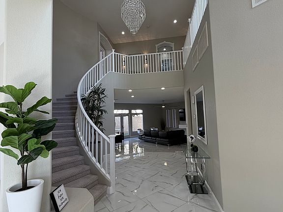 Entry view featuring the staircase extending to a spacious upper-level loft, with open views into the main living area below.