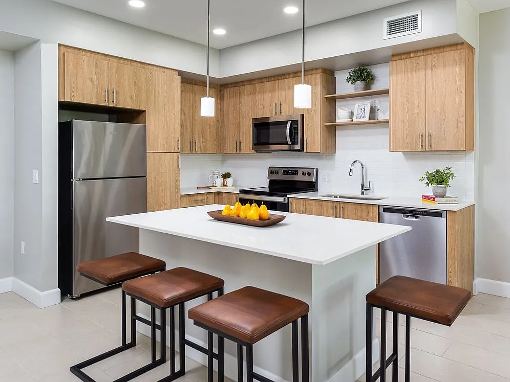 Open concept kitchen with quartz countertop, island, stainless steel appliances and tile backsplash - Avalon Doral