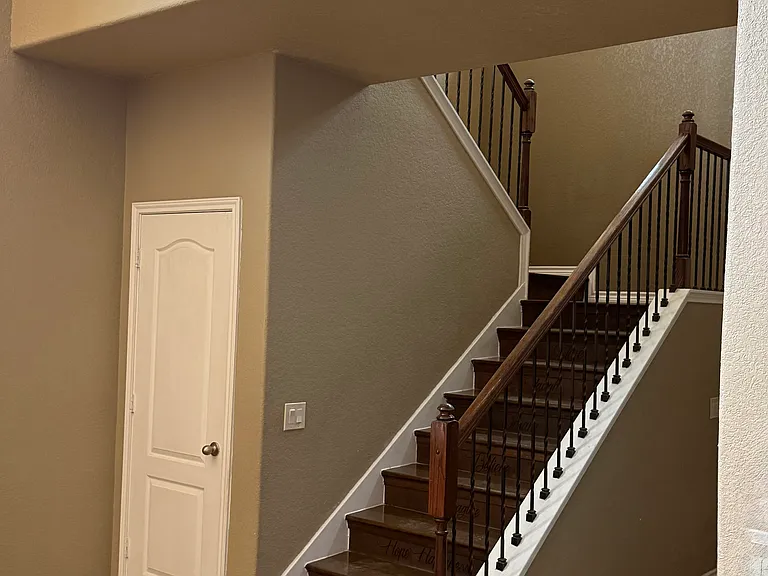 Storage under the double flight of stairs wraps around underneath and is lighted and carpeted