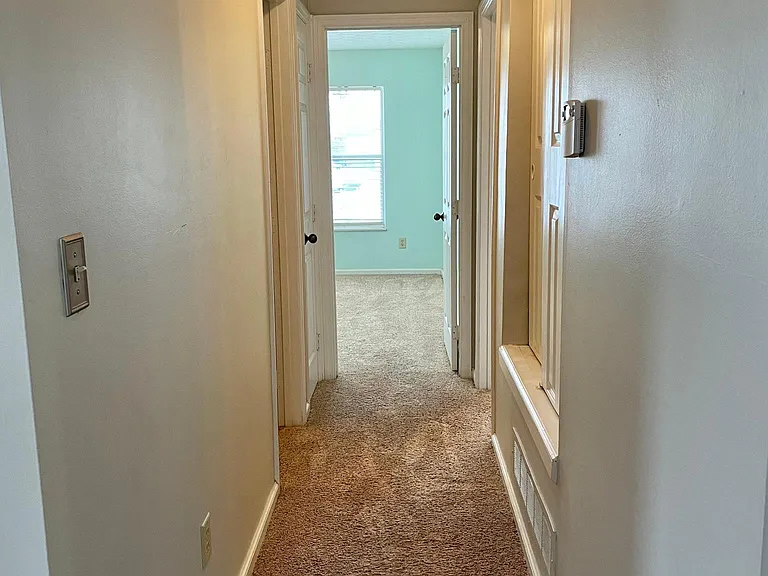 Hallway leading to bedrooms and bathrooms. Linen closet and closet with water heater and furnace.