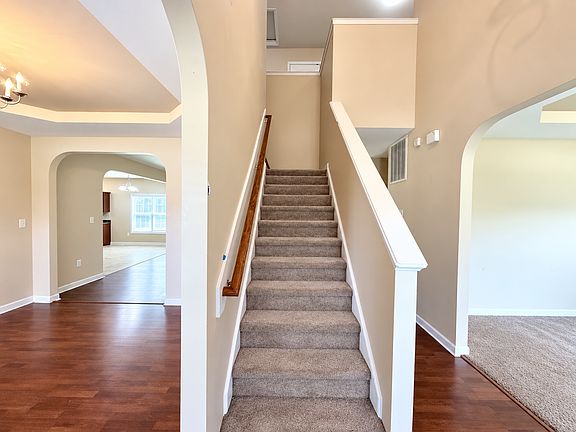 View from the front entrance featuring the staircase to the second floor, with the formal dining room to the left and versatile flex room to the right.
