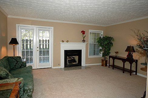 Large Family Room with gas fireplace and French doors that open to patio