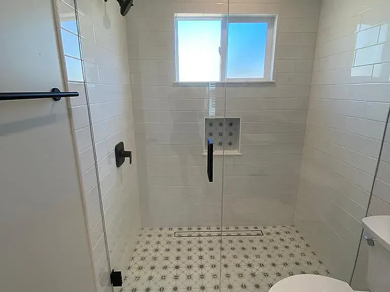 Walk in shower (no dam) cute beachy tile, shampoo niche subway white tile.