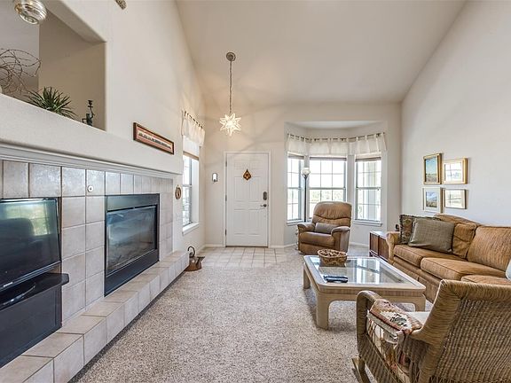 Living Room has Vaulted Ceiling and 2-Sided Fireplace.