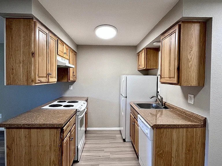 Inviting kitchen with warm wooden cabinets, sleek countertops, and modern appliances, perfect for culinary creativity.