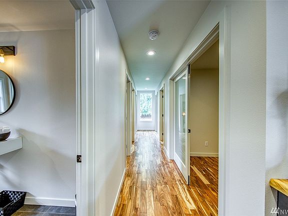 The central hallway spans the length of the building from the reception area and leads to five offices/service rooms.  The custom window at the end of the hall overlooks the back yard area.
