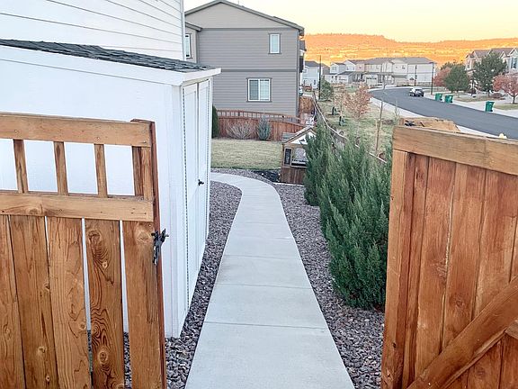 Sidewalk leading to backyard/ back patio. Also pictured is storage shed on side of house.