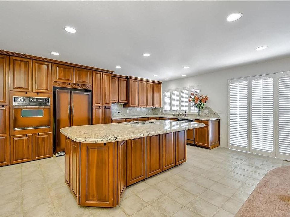 Open kitchen with custom wood cabinets Wood shutters New GE refrigerator not shown Extra refrigerator in garage shown Great place to entertain