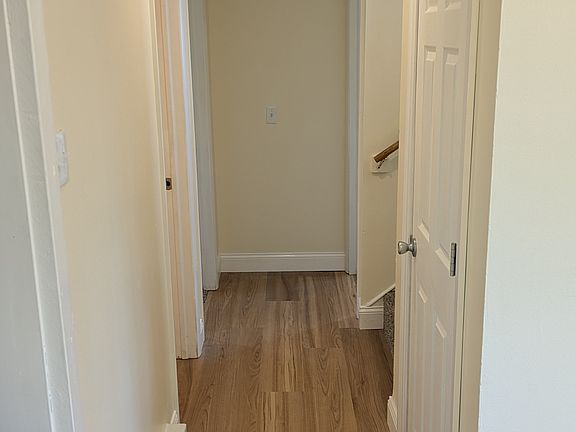 Main hallway that looks to the bedrooms, bathroom, and stairs to the front door.