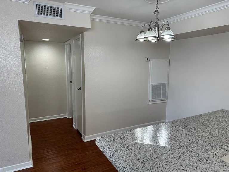 Bright apartment hallway with elegant lighting, featuring polished wood flooring and a sleek, modern countertop. Bright apartment hallway with elegant lighting, featuring polished wood flooring and a sleek, modern countertop.