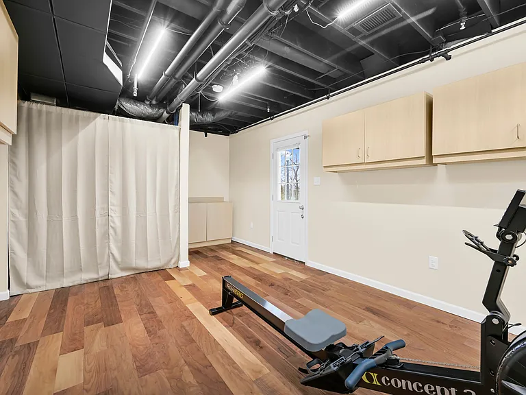 Finished Walkout Basement - oppoiste view facing door leading to the outside under the balcony