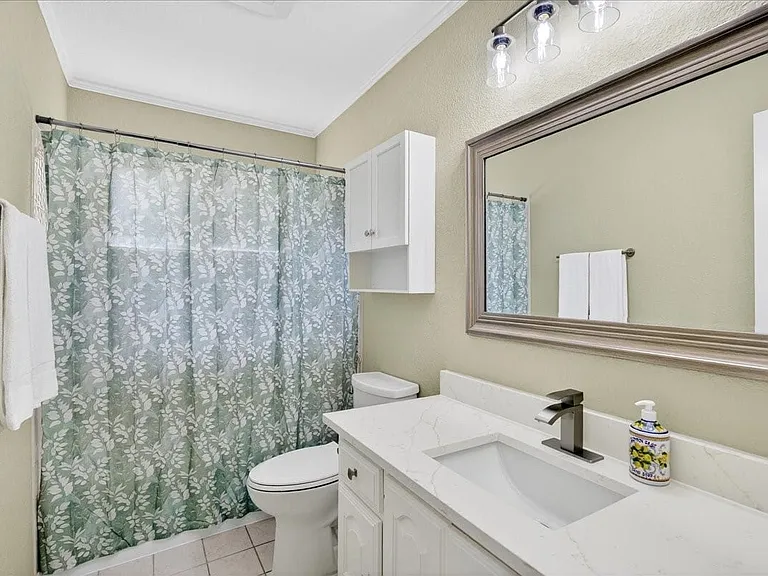 Guest bathroom with new quartz countertops, sinks, hardware, mirrors and faucets.