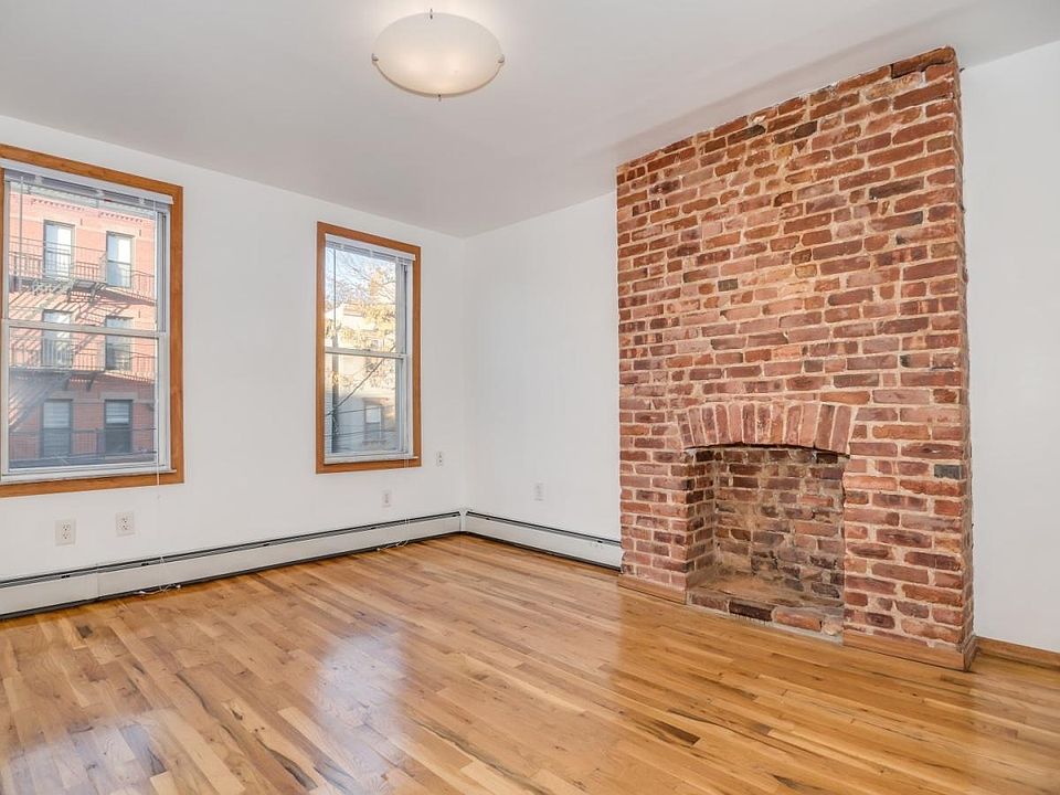 Beautiful Brick Mantle in Living Room with 3 cascading windows bringing in tons of natural sunlight!