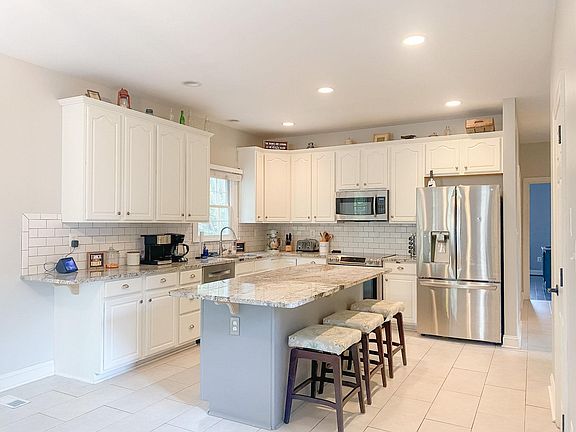Large kitchen with island, Bosch dishwasher, stainless steel appliances.