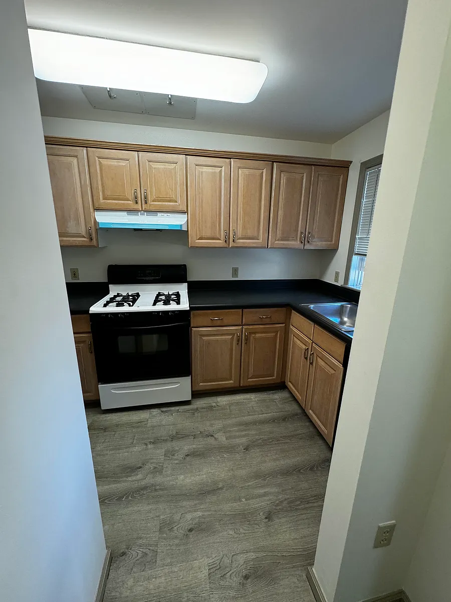 Kitchen area with grey vinyl flooring, oven/stove, refrigerator - 2205 Mayor Mitchell Ct