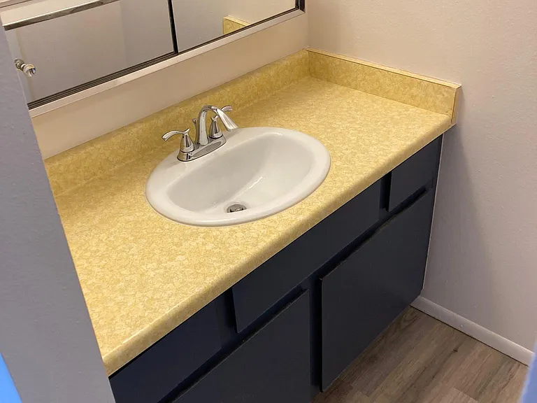 The bathroom is two rooms with a door separating the sink and vanity from the tub/shower and toilet for more privacy.