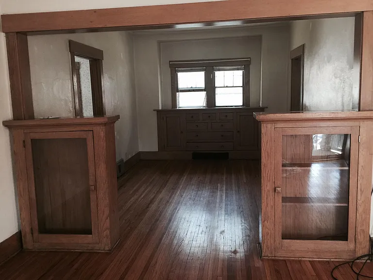 Looking from front door into living/dining area showing oak bookcase dividers & built in buffet at far end of room. Beautiful oak floors
