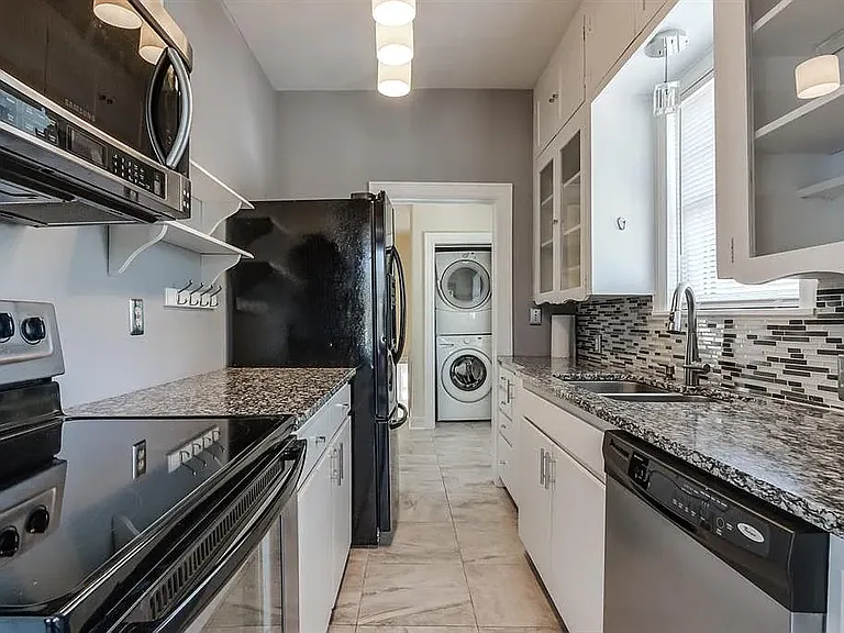 Kitchen view from dining nook. Washer / dryer room in background