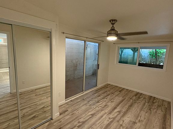 Bedroom with mirror closet doors, sliding door and luxury vinyl tile
