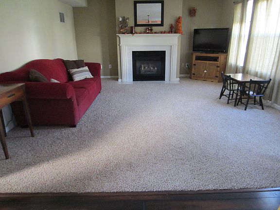 Open concept living room with fireplace and connected to kitchen.