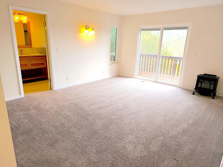 Large master bedroom looking on deck, with fireplace