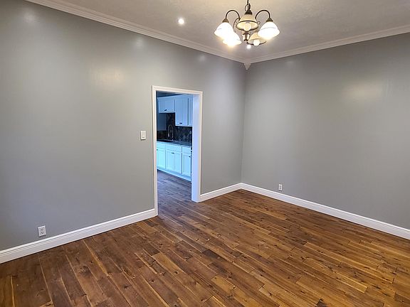 Huge living room with tall ceilings, hardwood flooring, and great lighting.