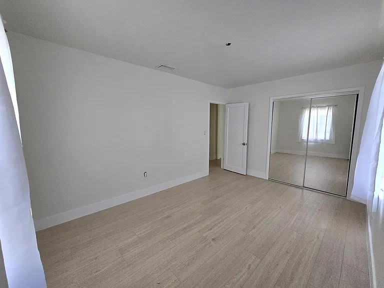 Master bedroom with mirrored closets at the front...