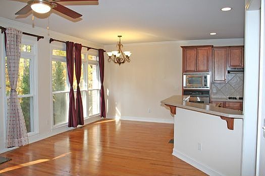 BREAKFAST ROOM HAS HARDWOOD FLOORS AND A DECORATIVE CHANDELIER.