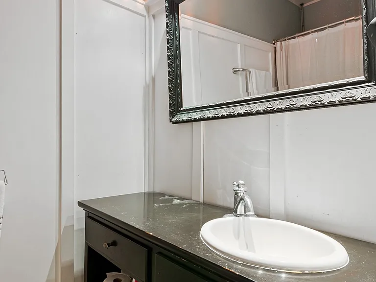Modern bathroom with a stylish quartz vanity, updated fixtures, and functional storage.