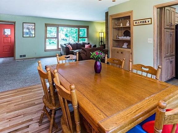The dining area features a built in niche and is open to the living room and fireplace