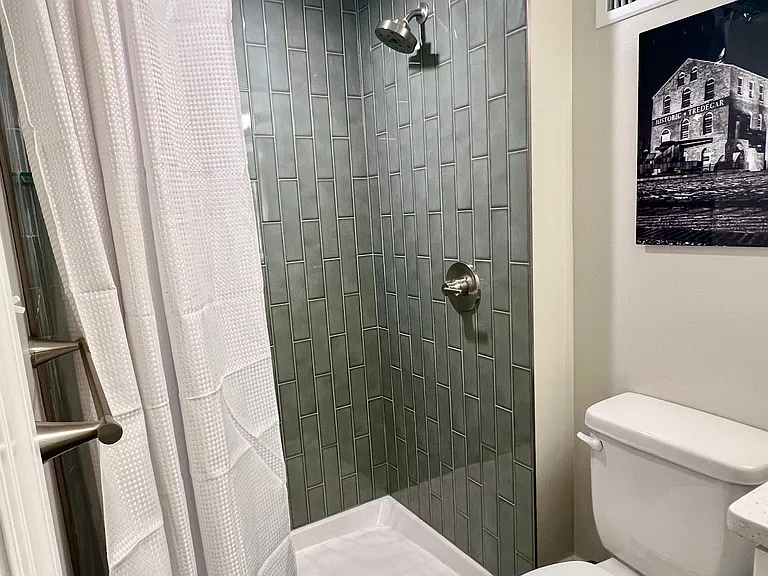 Shower with vertical subway tile in secondary bathroom.