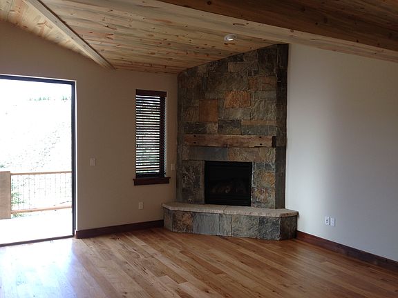 Living/family room gas stone fireplace, w/wooden beam mantle, hickory floors, vaulted ceiling