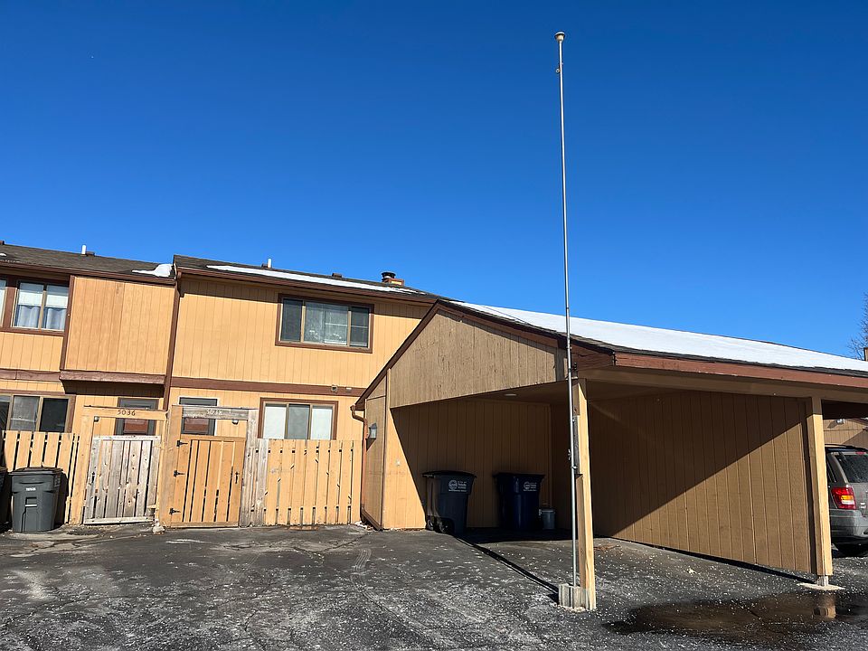 rear entry of unit with carport and 2 parking spots