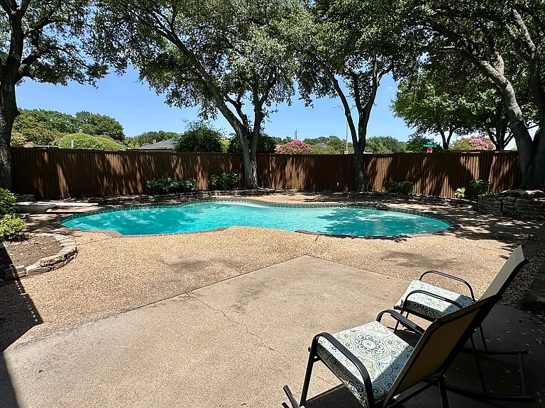 View of pool and patio with a fenced in backyard