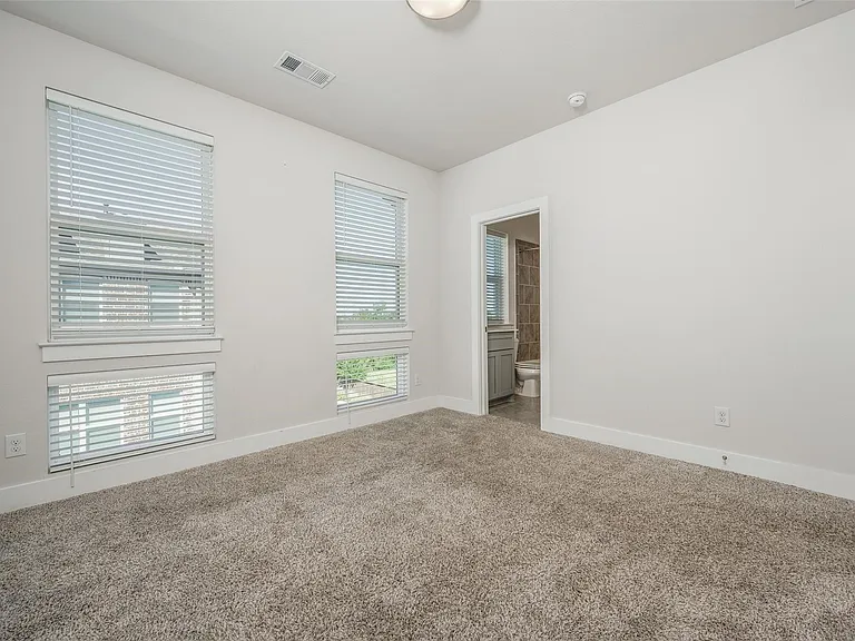Large Third Floor Bedroom with ensuite bath shows the blinds that are throughout the house.