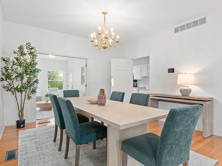 Spacious dining area with a large dining table and comfortable chairs, conveniently connected to the kitchen and sunroom.