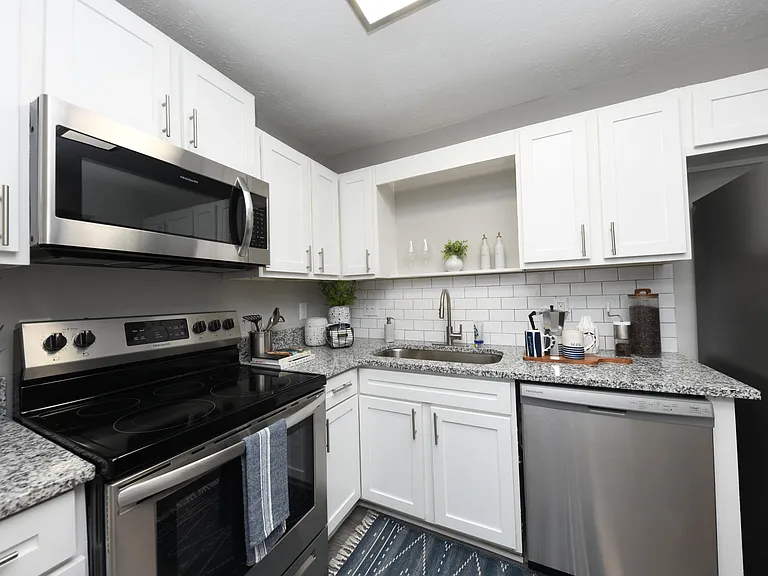 Kitchen with granite counters, modern cabinetry, and stainless appliances