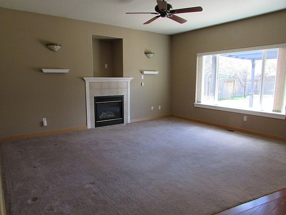 Living room with gas fireplace, carpeting, internet connection.