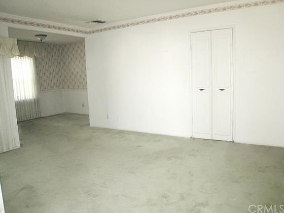 Spacious Living Room. Green may not be your color, but there are original hardwood floors underneath that have been covered for nearly 70 years are probably gorgeous!